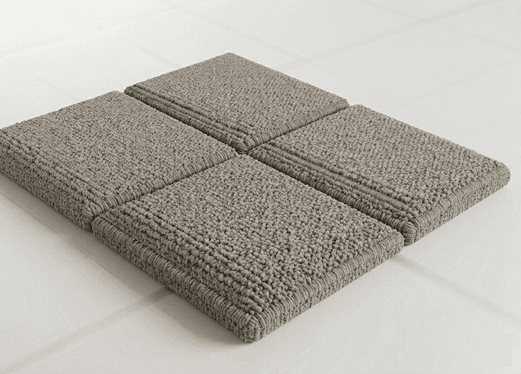 Modular carpet tiles in textured grey loop pile